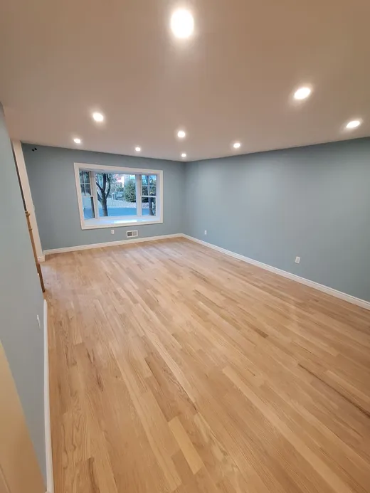 A renovated room with new hardwood floors ready for move-in